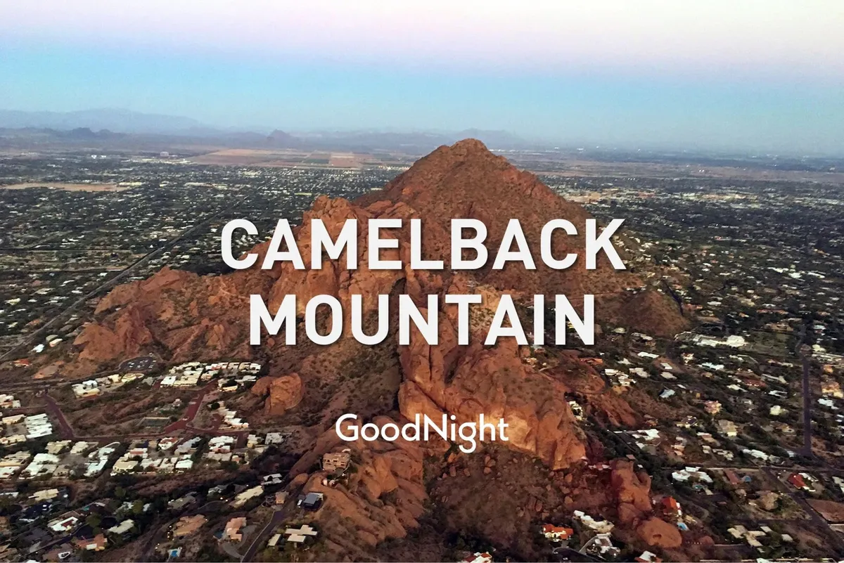 A panoramic view of Camelback Mountain and its surrounding landscape with residential areas scattered below. The scene is tranquil, suggesting opportunities for hiking, photography, and connecting with nature.