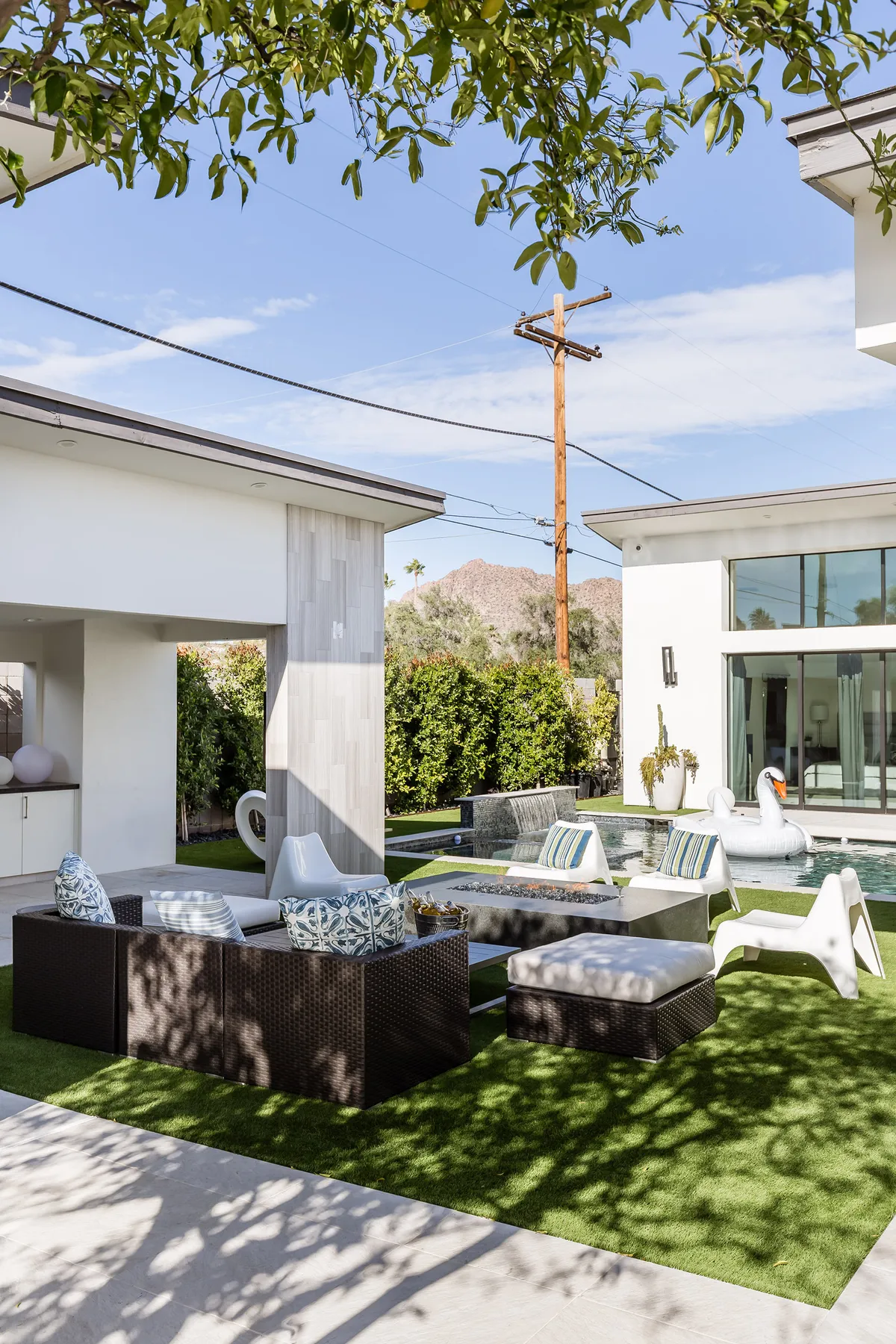 An inviting exterior shot highlighting the swimming pool surrounded by comfortable outdoor furniture and lush greenery. A decorative swan float adds a touch of playfulness, and the setting is ideal for sunbathing, swimming, or evening get-togethers.
